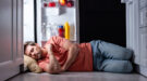 exhausted man sleeping on floor in kitchen near open refrigerator Slapen met hitte, tropische nachten