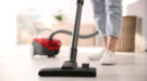 Young woman using vacuum cleaner at home, closeup stofzuiger