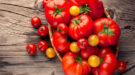 Verschillende soorten tomaten op een houten ondergrond.