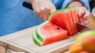 watermeloen-snijden-shutterstock_459157654-1200×667 Een persoon snijdt een watermeloen in stukken.