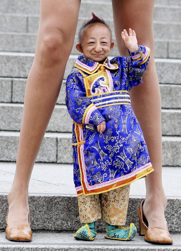 De kleinste man, samen met de vrouw met de langste benen ter wereld voor het Guinness World Records.