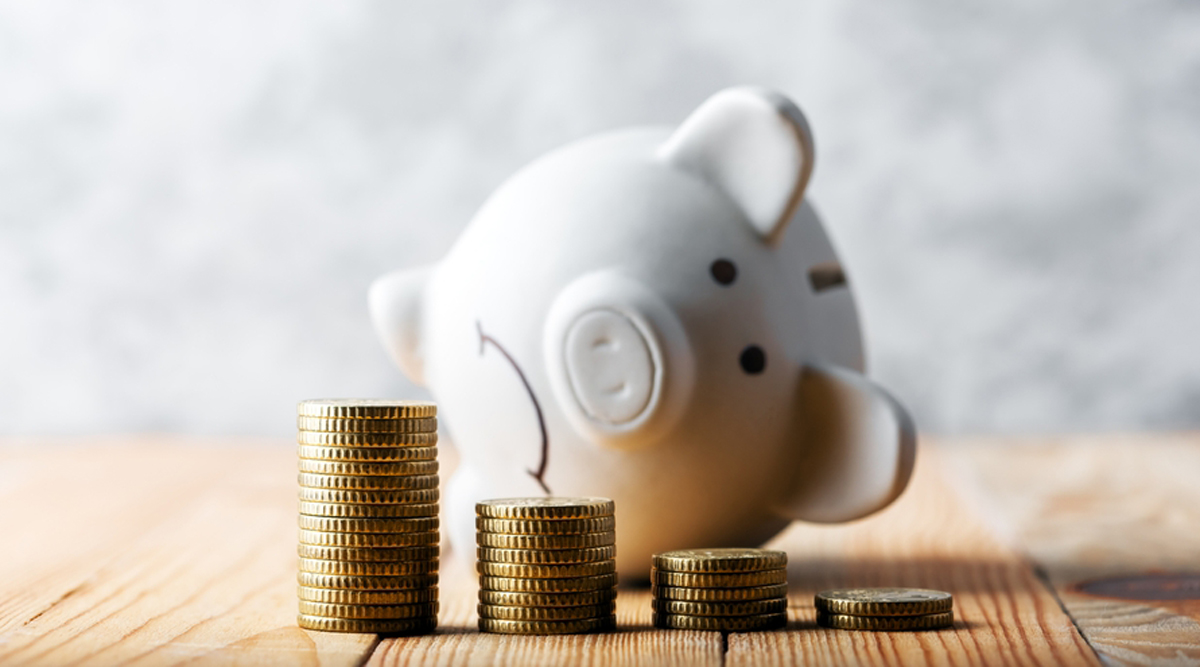 Spaarvarken op zijn kant met geld ervoor, een gehalveerd pensioen