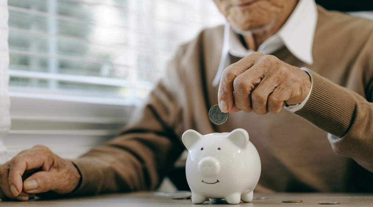 Man stopt geld in spaarvarken voor zijn pensioen