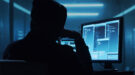 datalek-shutterstock_2289453963-1200×667 Een hacker zit voor een computerscherm in een donkere ruimte.