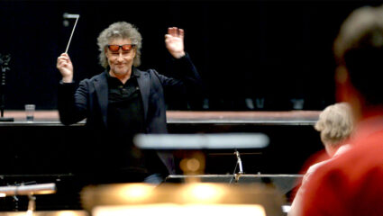 Dirigent Maurice Luttikhuis staat voor een orkest.