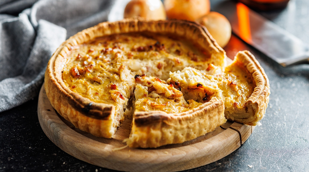 Een afgesneden punt van een versgebakken quiche.