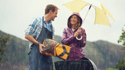 Stel probeert de barbecue aan te steken tijdens de regen.
