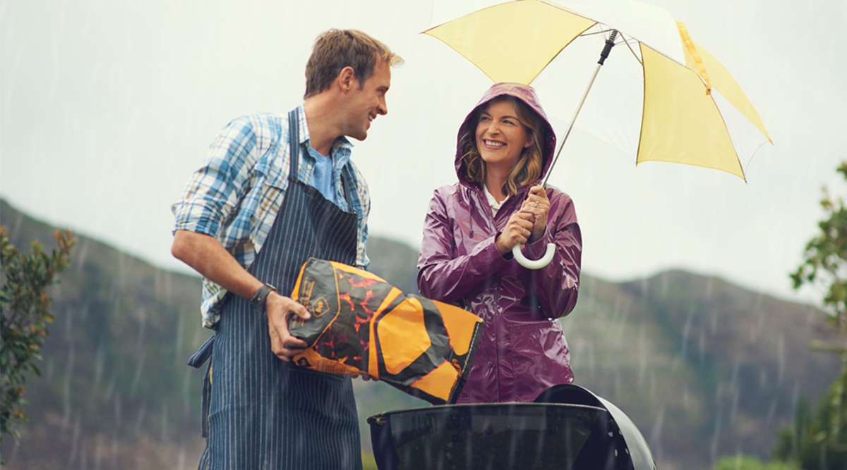 Stel probeert de barbecue aan te steken tijdens de regen.