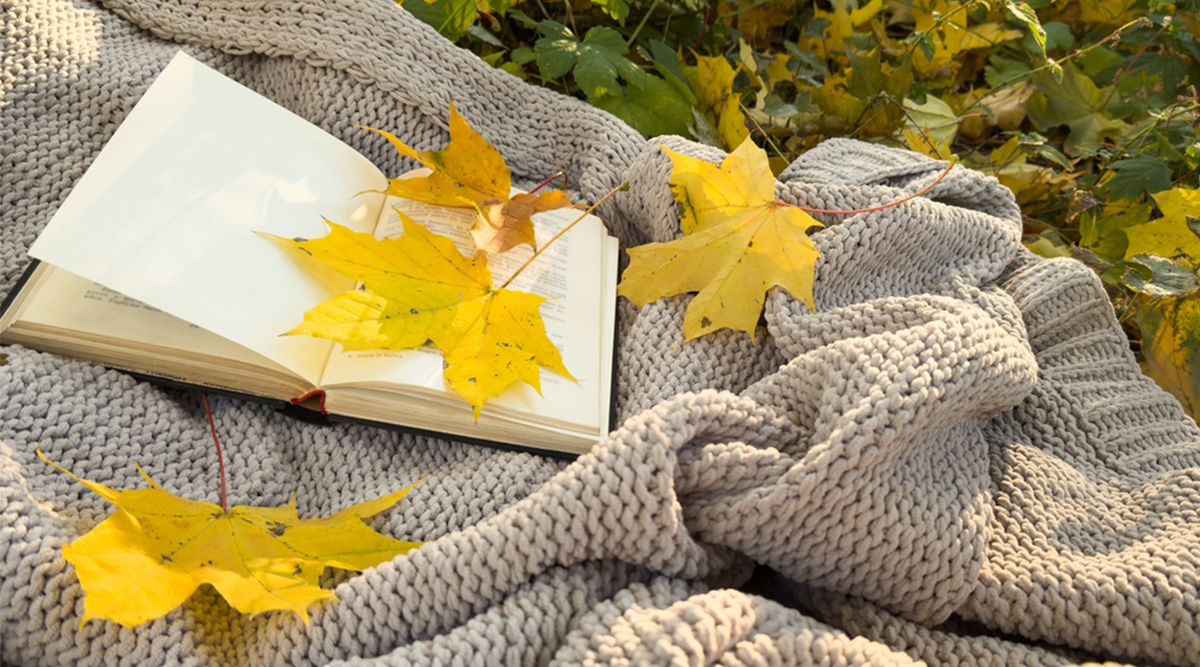 Een gehaakte deken met herfstbladeren.
