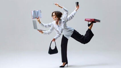 Een vrouw is aan het multitasken: bellen, lezen, schrijven.