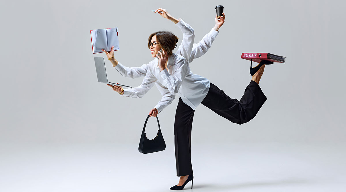 Een vrouw is aan het multitasken: bellen, lezen, schrijven.