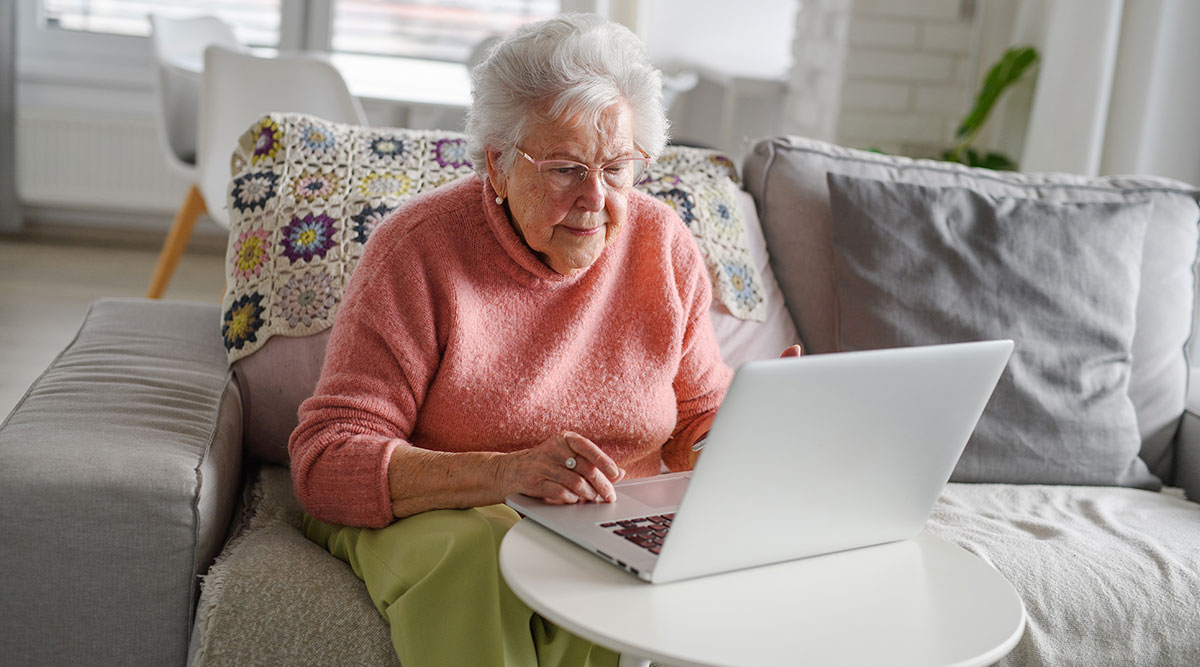 Een vrouw zit achter haar laptop. Ze heeft een phishingmail ontvangen.