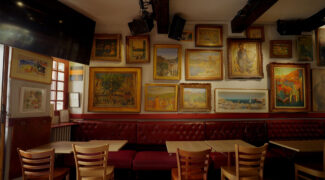 De binnenkant van een bijzondere bar in Collioure, waar schilderijen hangen van bekende schilders.