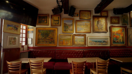 De binnenkant van een bijzondere bar in Collioure, waar schilderijen hangen van bekende schilders.