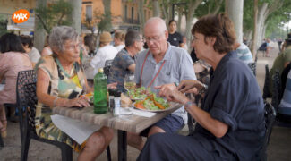 Martine van Os zit aan tafel met kampeerders Ine en Rob uit We zijn er Bijna! te eten.