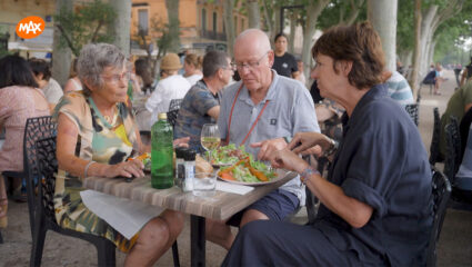 Martine van Os zit aan tafel met kampeerders Ine en Rob uit We zijn er Bijna! te eten.