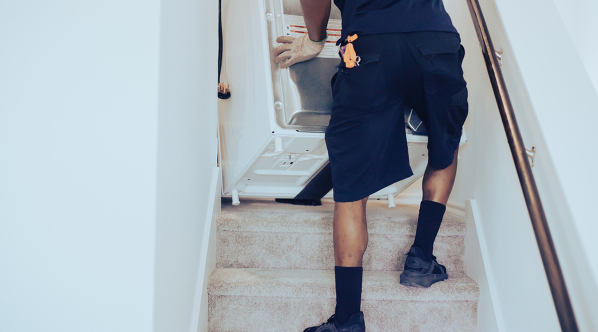 Man tilt wasmachine de trap op