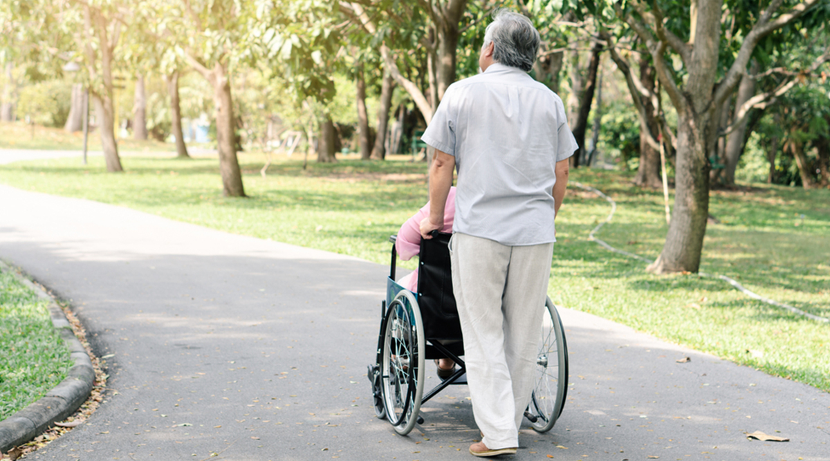 Oudere man en zijn vrouw die in een rolstoel zit. Theo en Gerda.