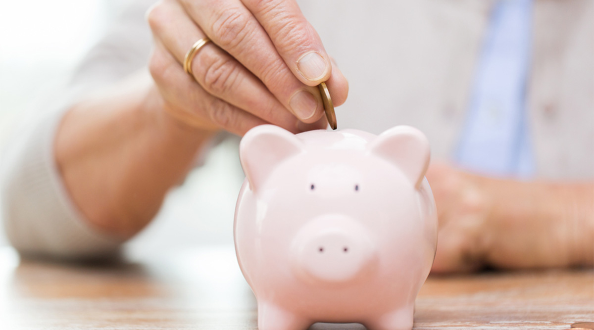 Mevrouw stopt geld in een spaarvarken.