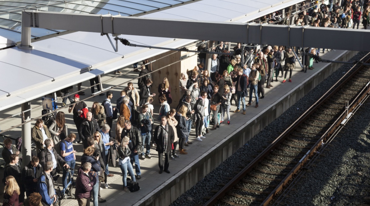Mensen staan op het perron op de trein te wachten.