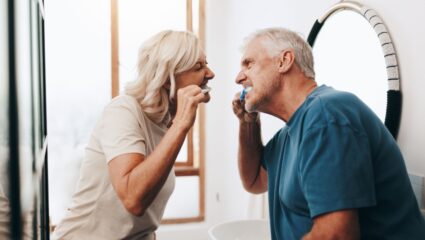 Een man en vrouw zijn hun gebit aan het poetsen.