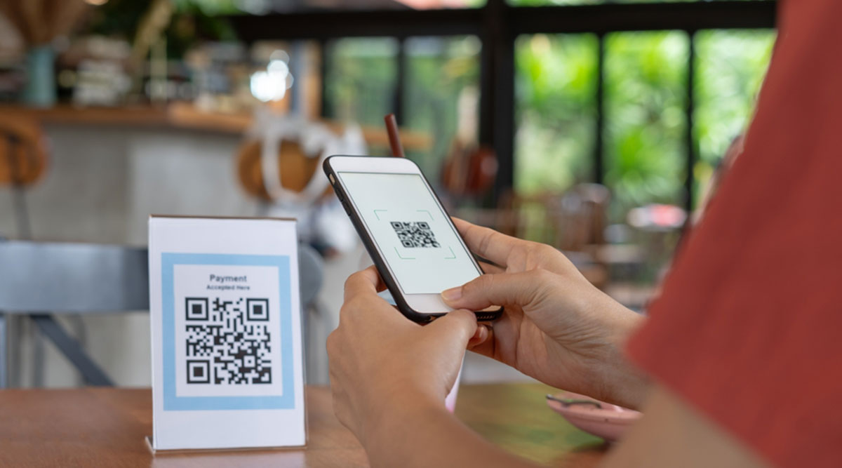 Een vrouw scant een QR-code in een restaurant