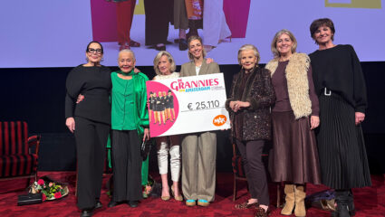 De Grannies van Amsterdam en Martine van Os overhandigen een cheque.