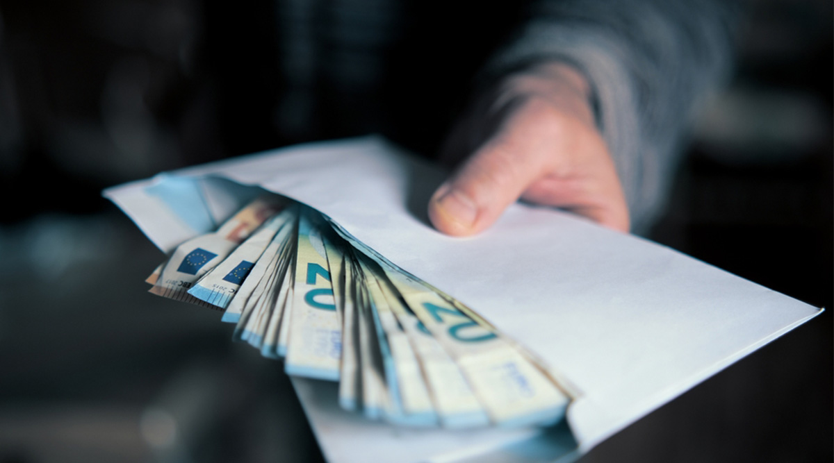 Meneer heeft een envelop met geld in de hand.