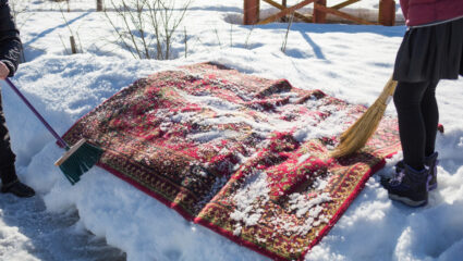 Vloerkleed wordt schoongemaakt met sneeuw.