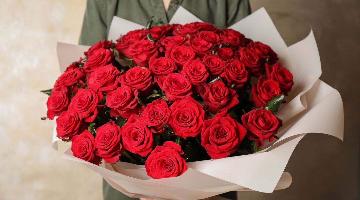 Vrouw met boeket rode rozen