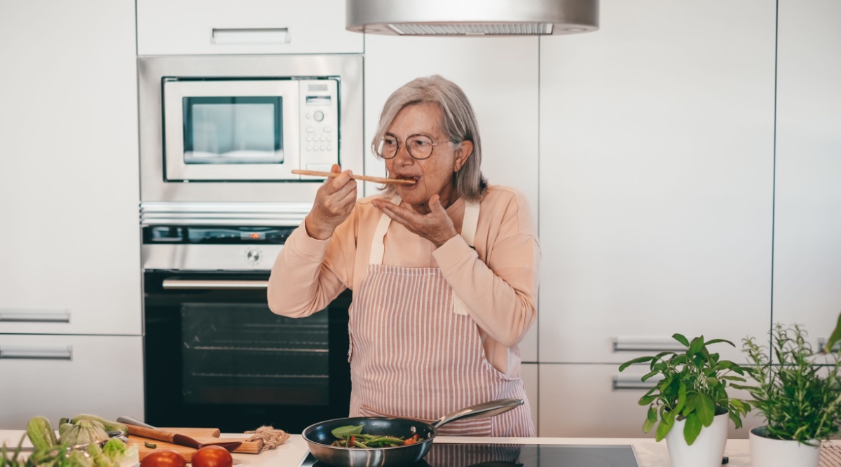 Een vrouw staat in de keuken te koken