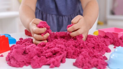 Meisje speelt met speelgoedzand.