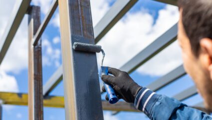 iemand verft een paal van metaal