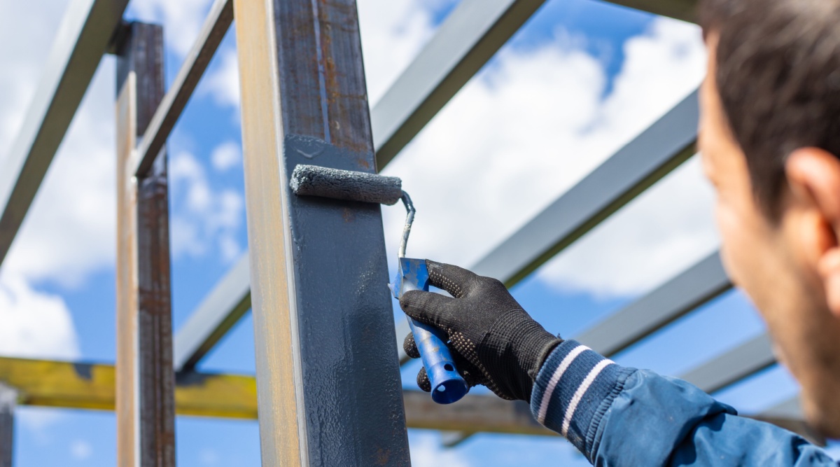 iemand verft een paal van metaal