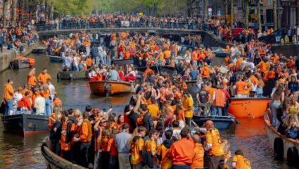 Koningsdag Amsterdam mensen in oranje kleding op boten
