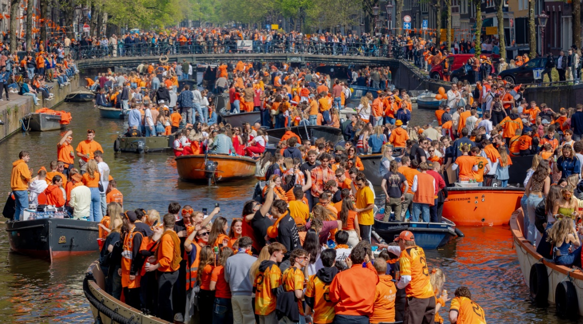 Koningsdag Amsterdam mensen in oranje kleding op boten