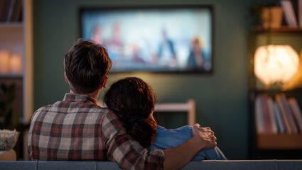 Een stel zit een film te kijken op de bank.