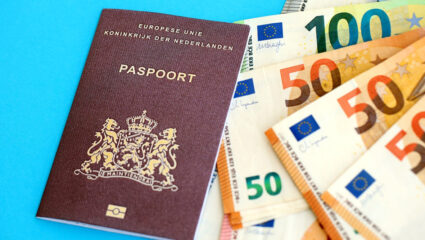 Paspoort en geld. Als symboliek: iemand met een AOW krijgt meer vakantiegeld in 2026.