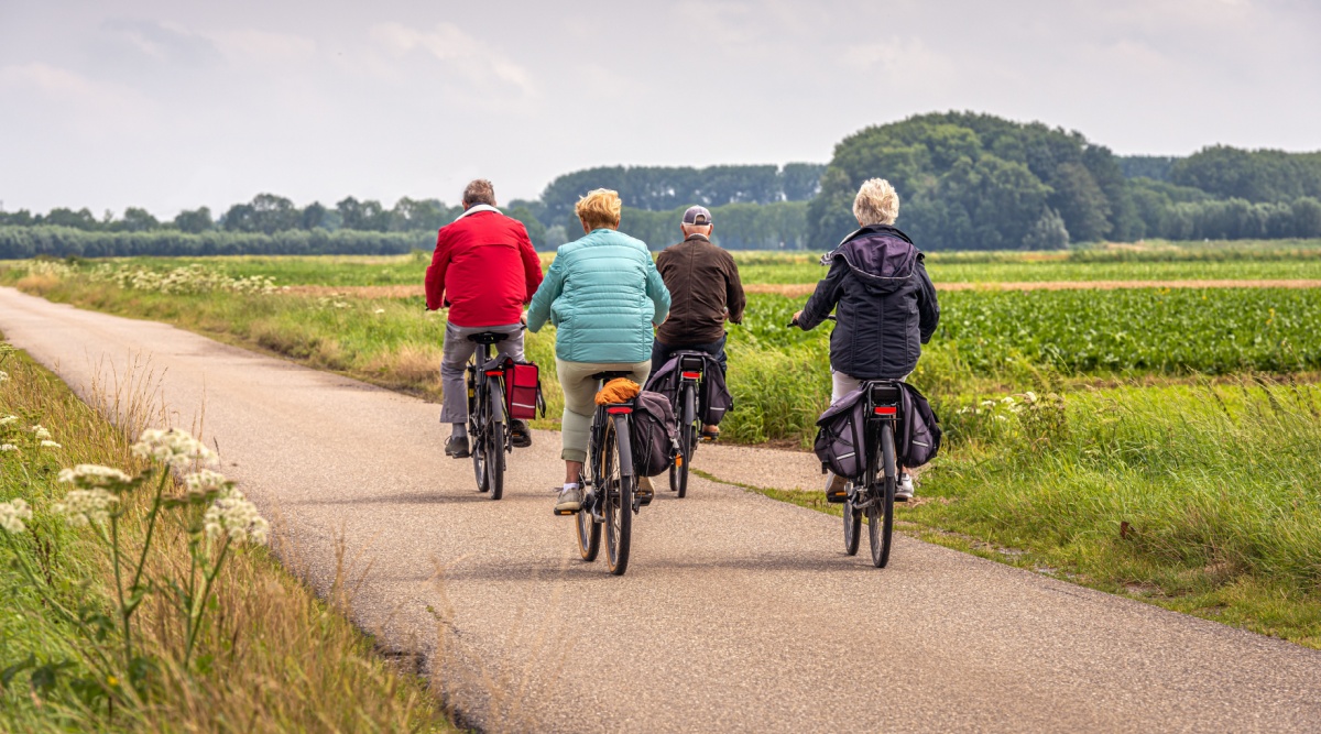 4 mensen op fietsen met fietstassen