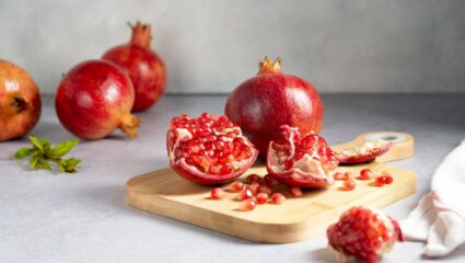 Opengesneden granaatappel op houten snijplank