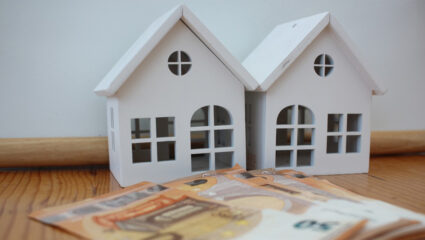2 huisjes en geld als symbool voor huurverhoging.