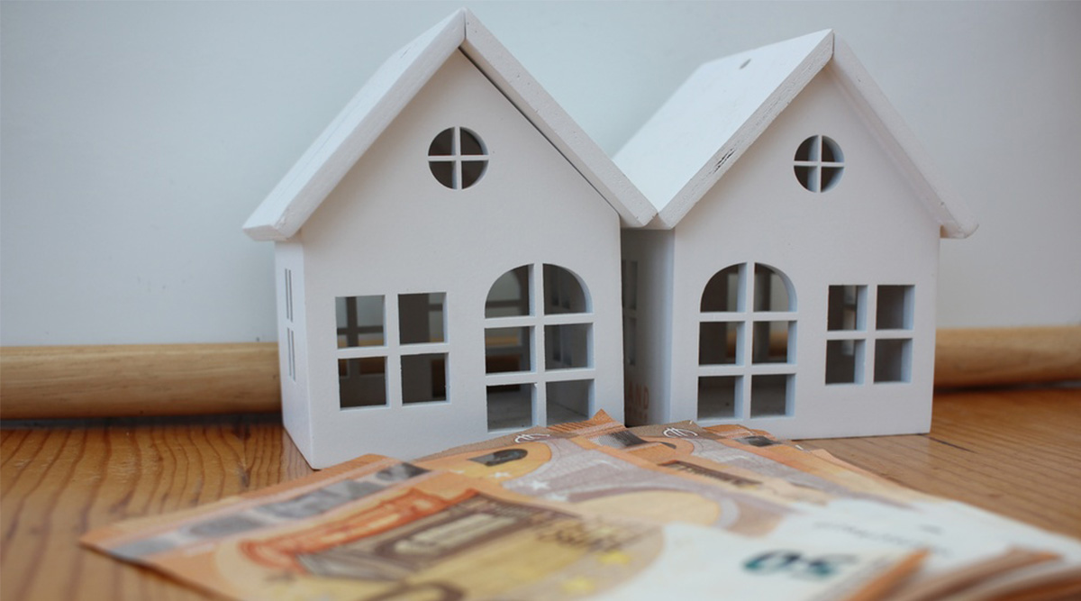 2 huisjes en geld als symbool voor huurverhoging.