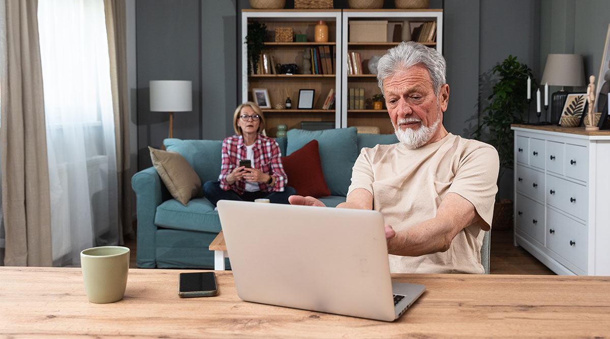 Een man achter een laptop en een vrouw op de bank, ze bespreken hun pensioengat.