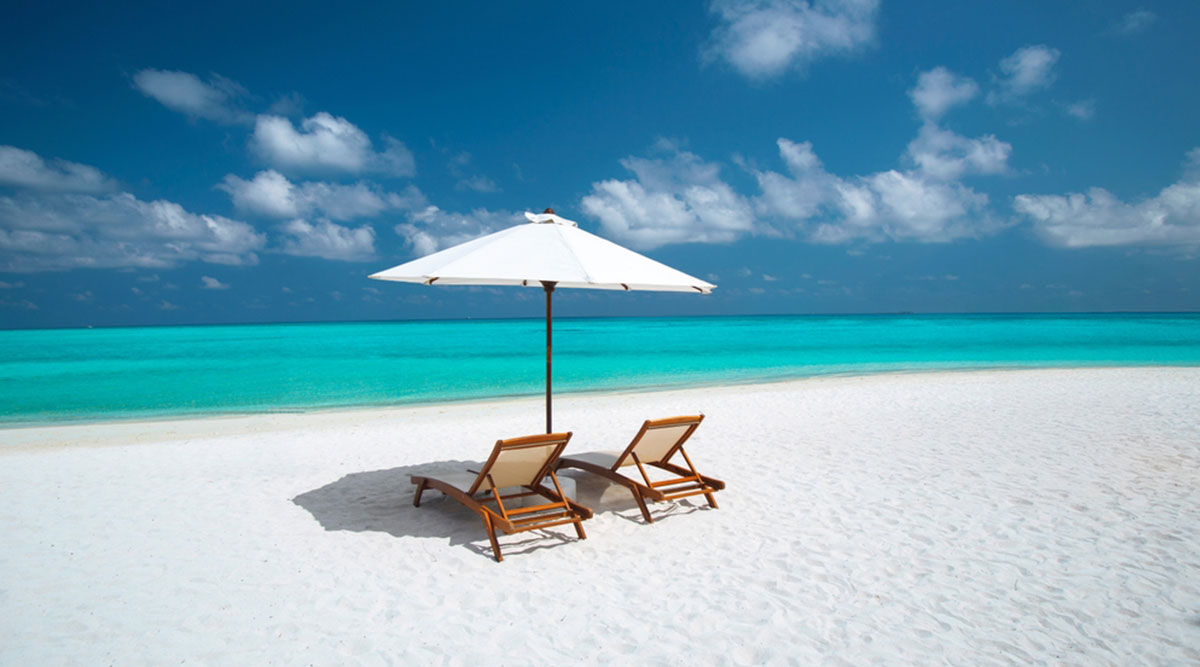 Puzzel: stoelen op een tropisch, wit zandstrand