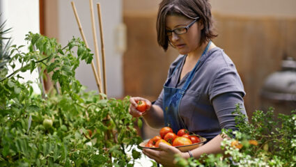 Een vrouw met haar oogst tomaten