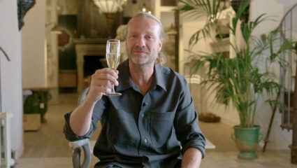 Bas Jonker uit Van onschatbare waarde proost met een glas champagne.
