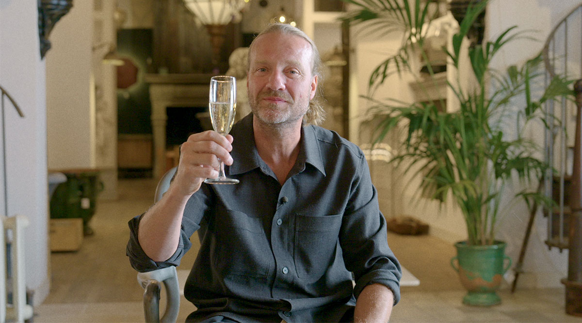 Bas Jonker uit Van onschatbare waarde proost met een glas champagne.