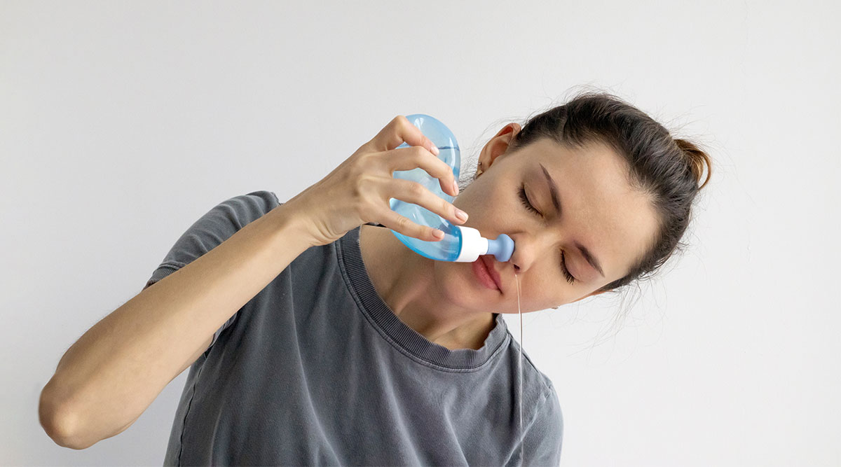 Een vrouw gebruikt een neusdouche.