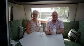 Kampeerders Lidya en Jan uit We zijn er Bijna! 2026 zitten in hun caravan.