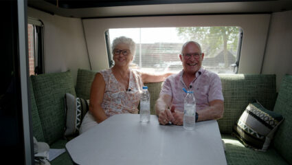 Kampeerders Lidya en Jan uit We zijn er Bijna! 2026 zitten in hun caravan.